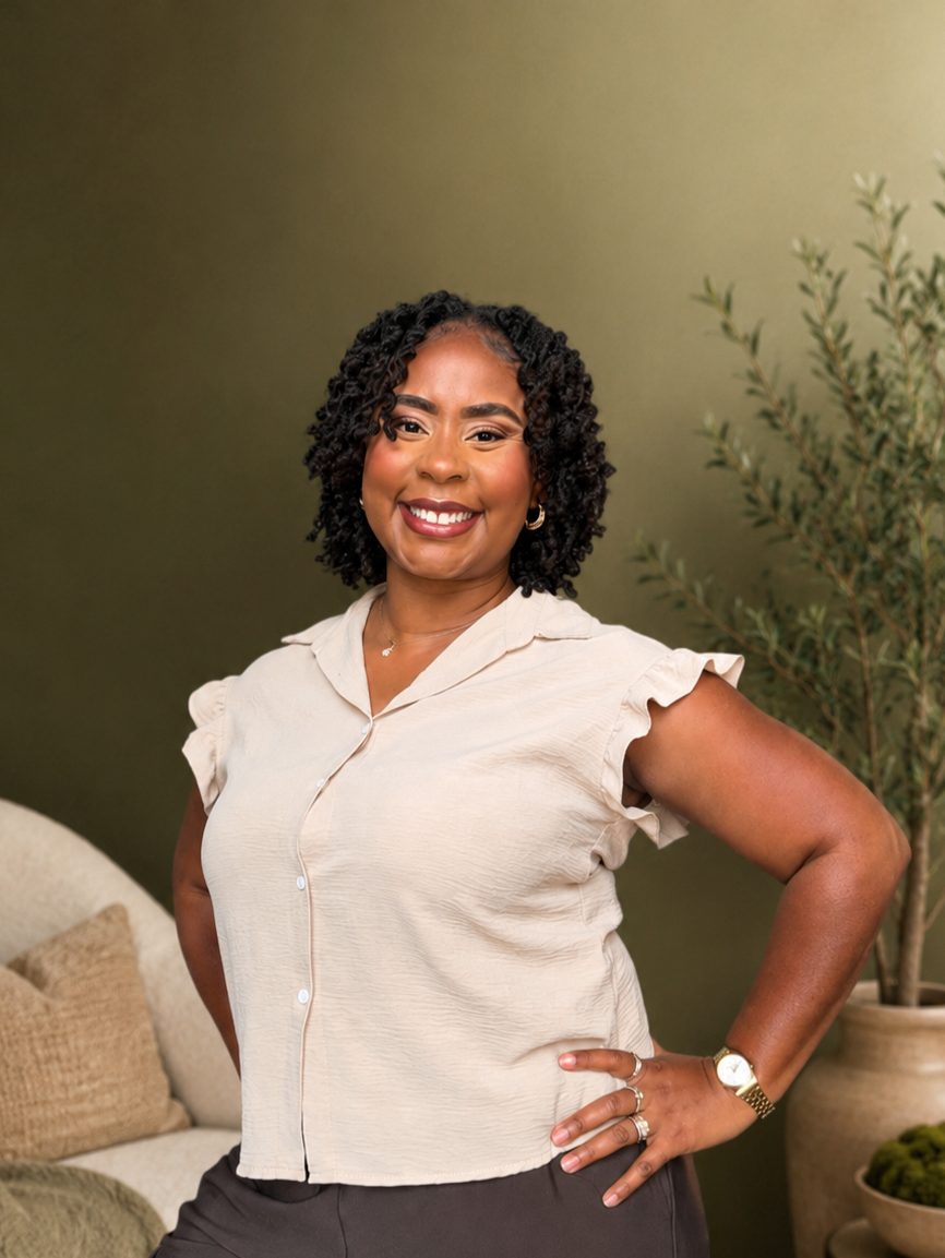 Shonta J. Caruthers standing in a warm, plant-filled studio